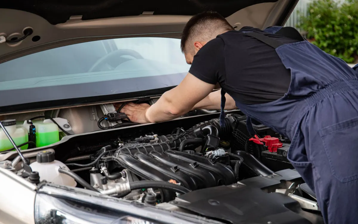An automotive electrician working on a vehicle.