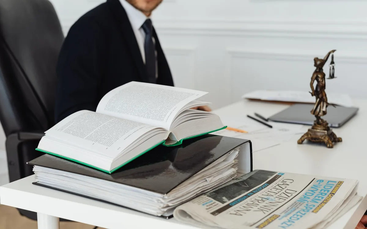 Law books and a set of scales of justice on an office desk