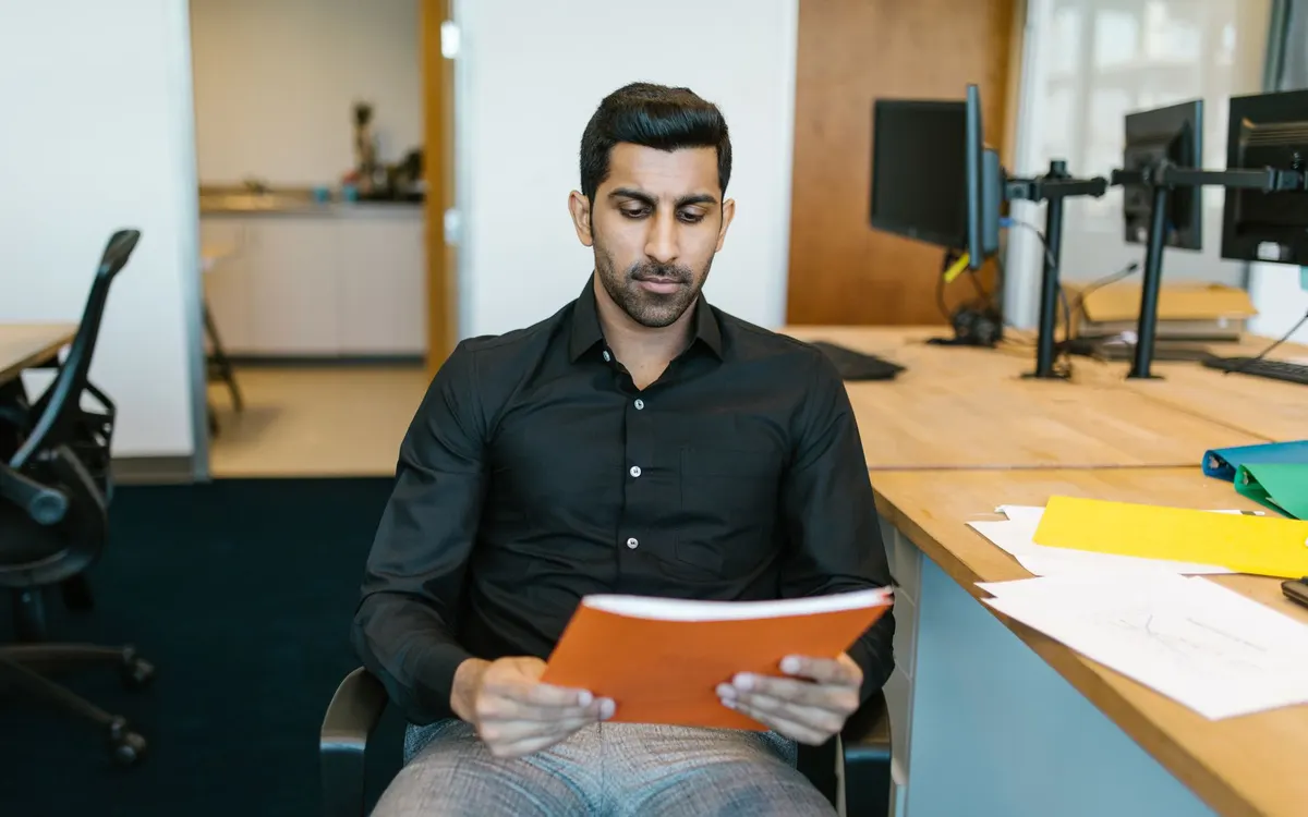 Reading an official letter at a desk.