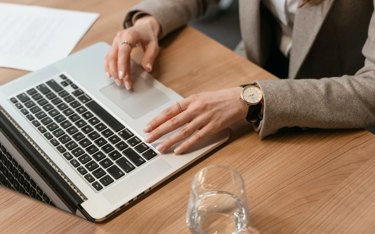 A person checking an application on a laptop at a desk