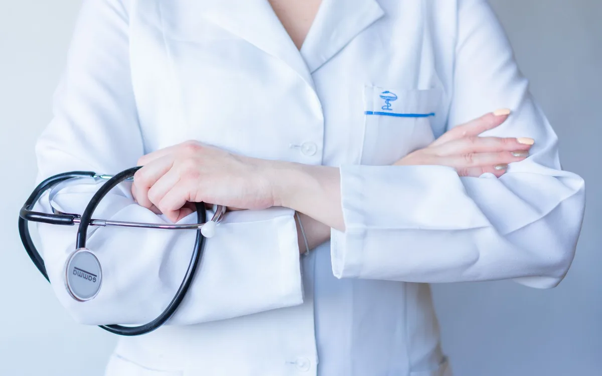 A doctor in a white coat holding a stethoscope