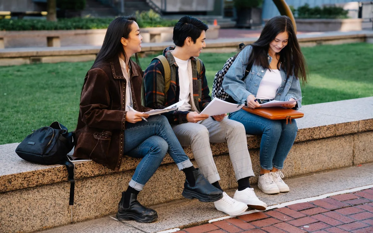 Students sitting together with books on a university campus
