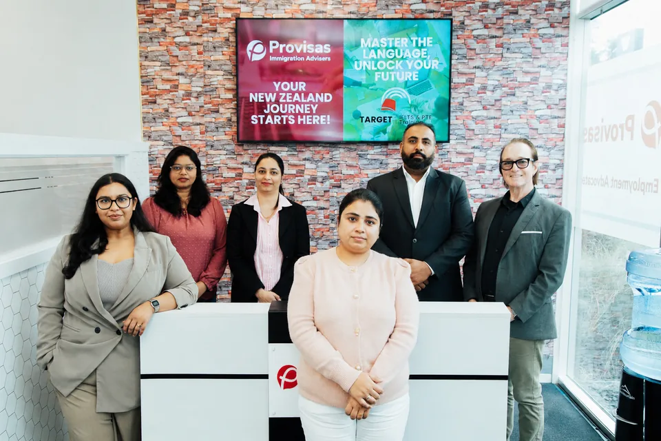 Provisas team at the Manukau office reception with the Target Language Academy 'Master the Language, Unlock your Future' campaign on screen.